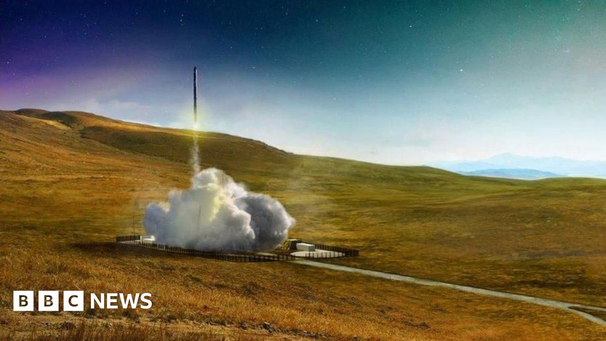An aerial image of SaxaVord spaceport under construction on the island of Unst in Shetland. There is a launch pad with a launch tower on a flat area of land above sheer cliffs to the sea below.
