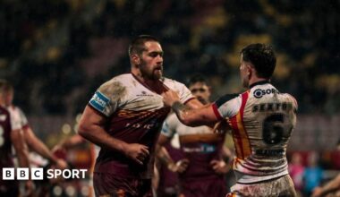 Huddersfield's Sam Hewitt and Catalans' Toby Sexton confront each other, grabbing shirt collars