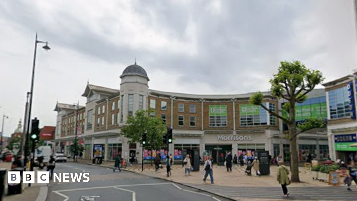 A Google image of Wimbledon Broadway - there are people shopping and cars driving along the road.