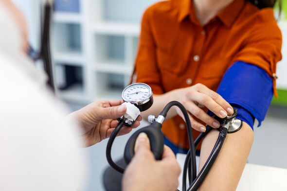 Close up of doctor checking blood pressure with manual gauge and stethoscope. Professional medical examination for hypertension and cardiovascular hea