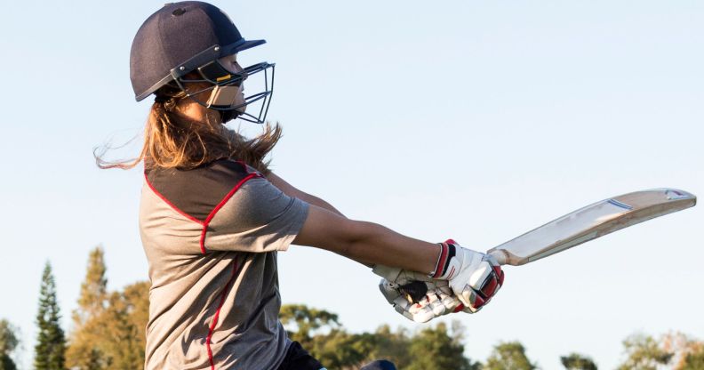 Someone swinging a cricket bat.