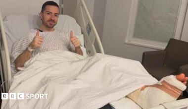 Midfielder Jack Grealish posing in a hospital bed with a bandaged foot