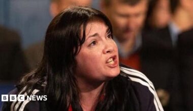 Suzanne Vjestica-Brown has long dark hair and is shouting instructions to a fighter.