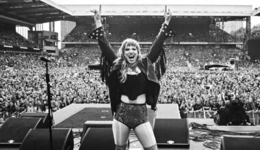 Lzzy Hale onstage at Villa Park, arms aloft with her back to the audience
