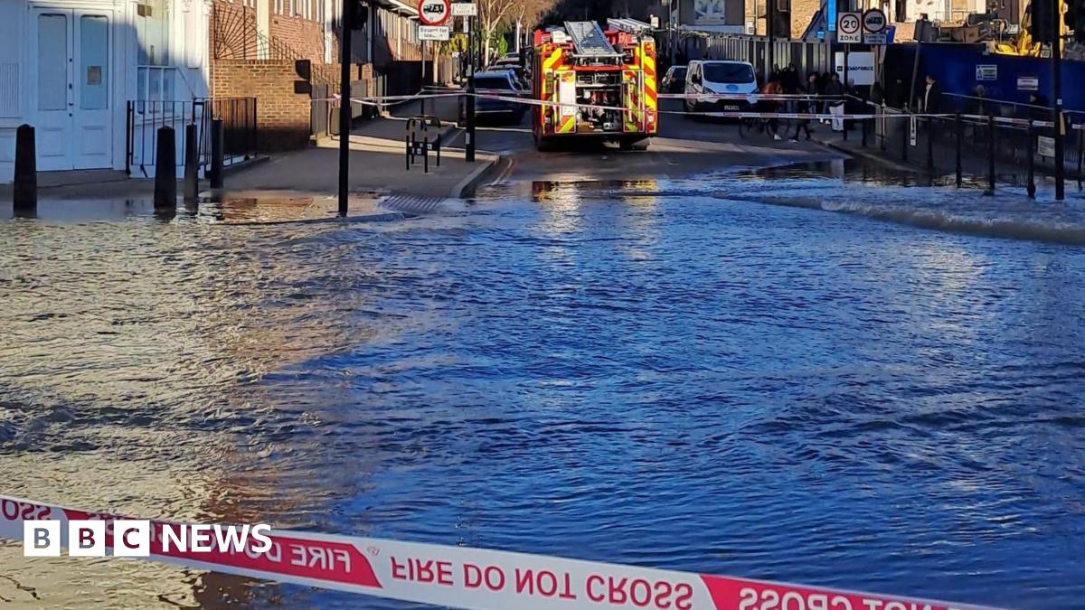 A view of flood water behind a cordon. There is a fire engine parked on the opposite side of the water.