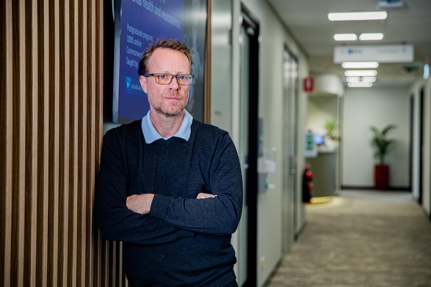 Alain Brunet stands in a hallway 