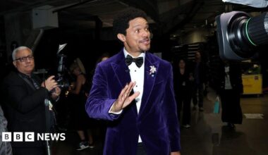 Trevor Noah wearing a purple suit at the Grammys.