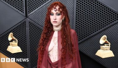 Chappell Roan in chiffon blood red Mugler dress and cape on the Grammys red carpet