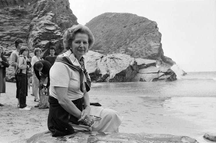 Margaret Thatcher sat on a beach