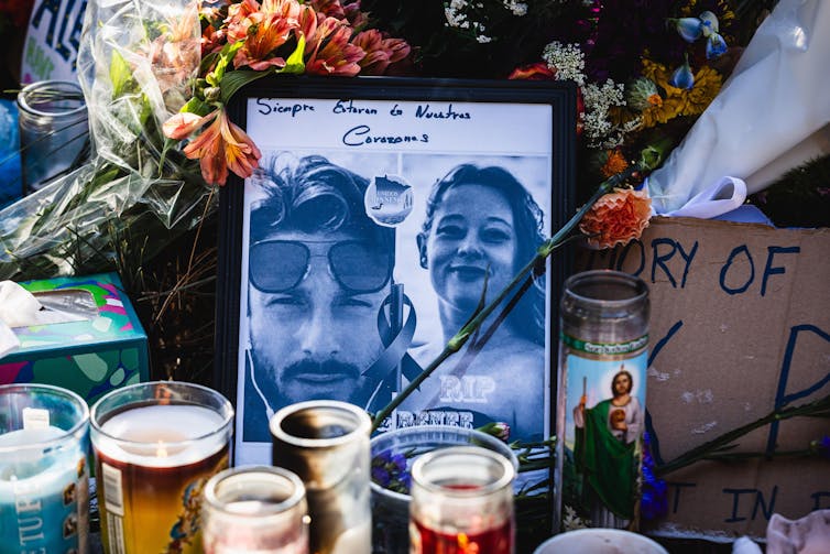 A memorial to a man and a woman with candles and notes.