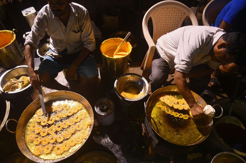 Workers of a sweet manufacturer prepare jalebis sweet on the occasion of the Hindu festival of Dussehra during early morning in Mumbai, on October 25, 2020.