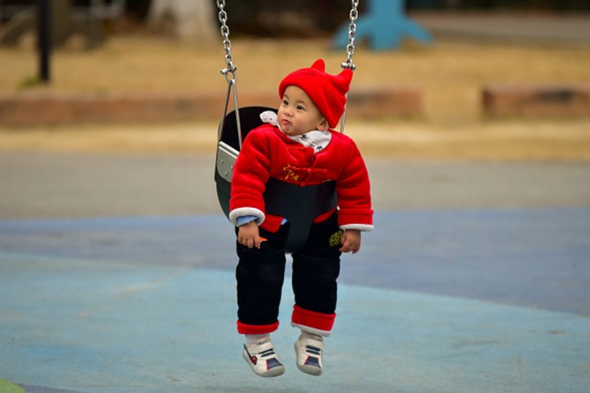 A toddler hangs out on a swing at a park in China's Fuyang city in January.