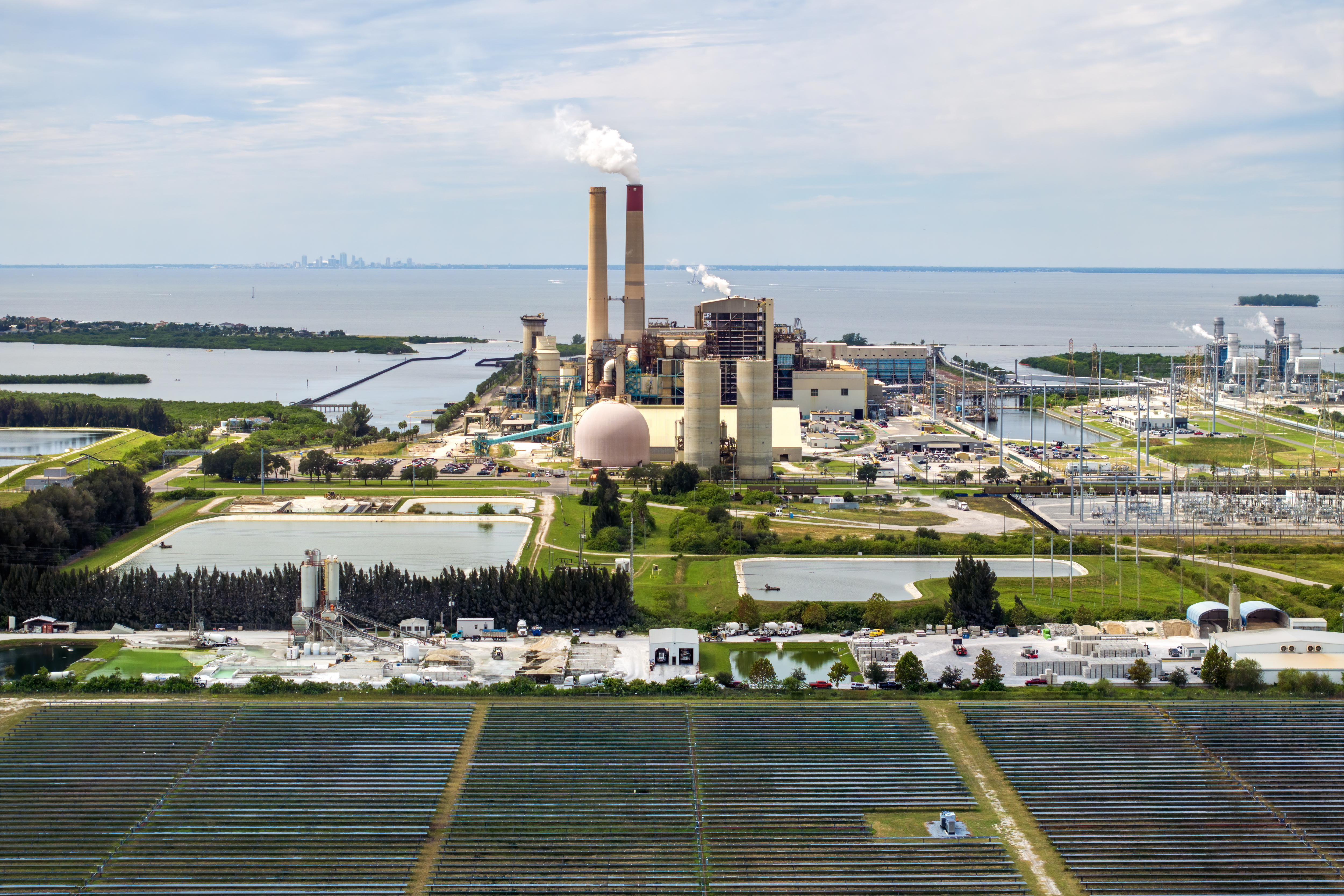 Aerial view of sustainable energy development at Florida Big Bend Power Station. Solar panels symbolize the shift from traditional fossil fuels to clean, emission-free electricity production.