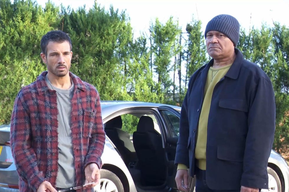 hollyoaks, dodger savage and donny clark standing outside a car in the woods