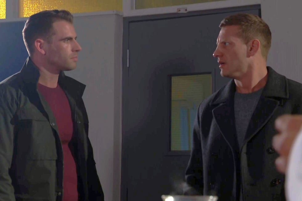 hollyoaks smithy and john paul inside a classroom looking at each other