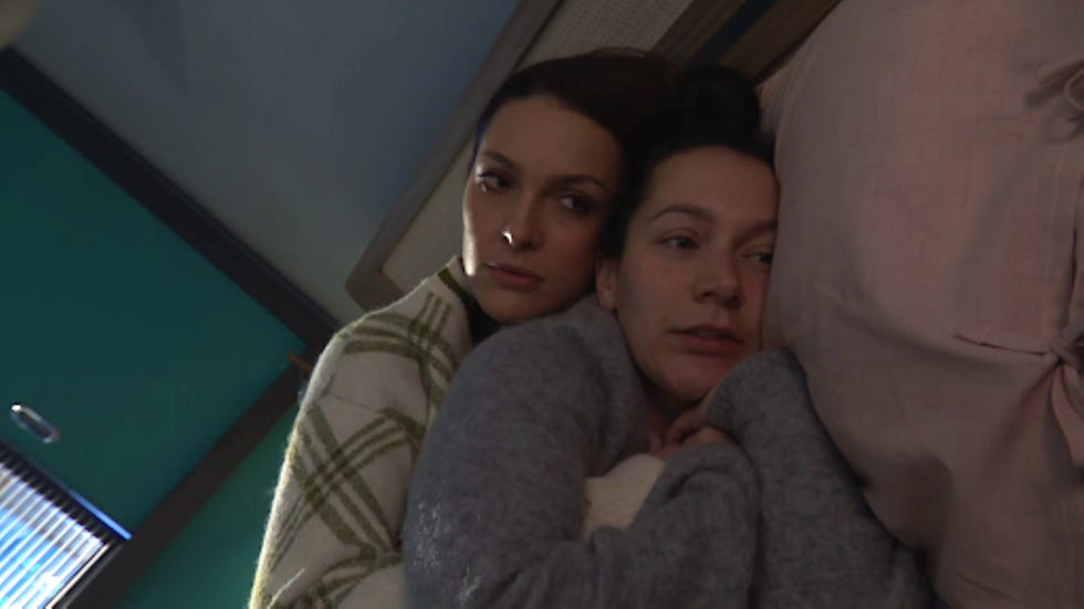 hollyoaks sienna blake cleo mcqueen two individuals lying closely together on a bed