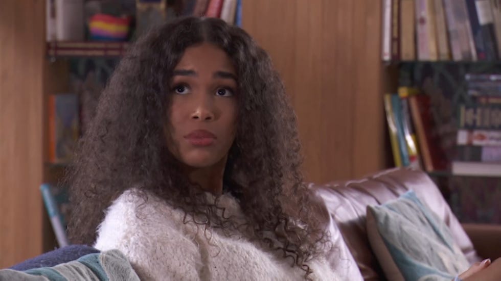 individual sitting on a couch in a cozy indoor setting