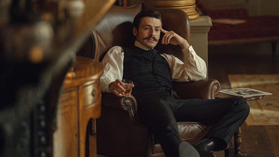 house of guinness anthony boyle as arthur guinness sitting in a chair, with a drink in his hand, looking troubled