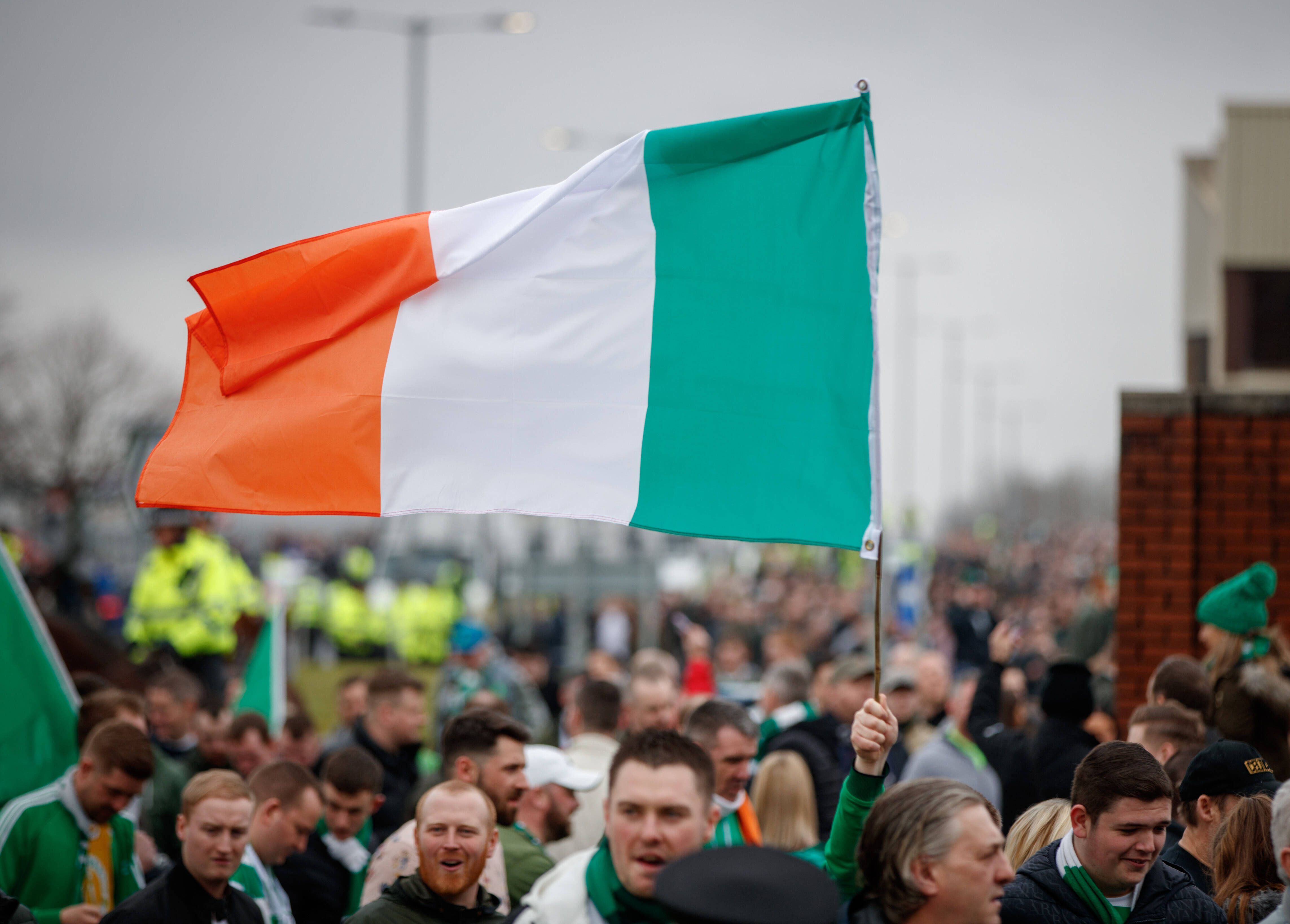A Celtic fan flies an Irish Tricolour on the way to Ibrox on Beautiful Sunday