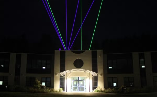 lasers emerging from the top of a building at night