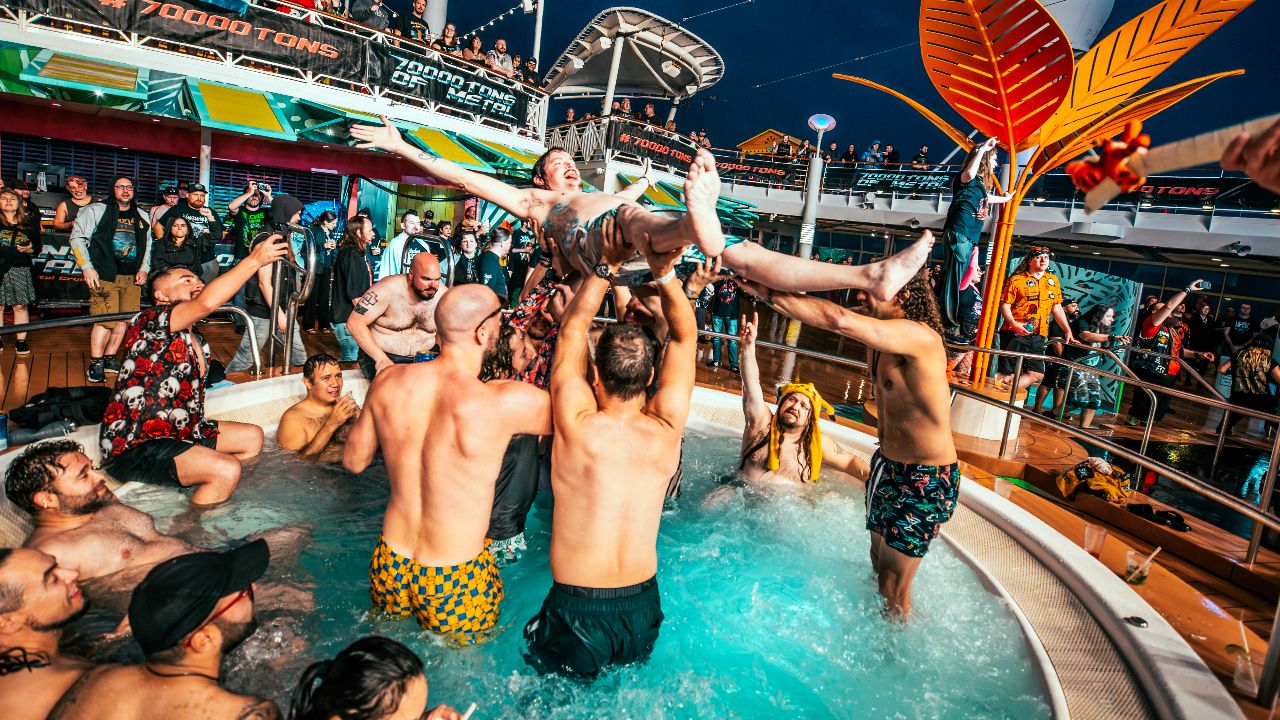 A man crowdsurfing over a busy hot tub
