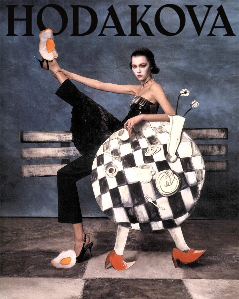 an editorial portrait by Szilveszter Makó of a model leaning against a checkered table with drawings of dishes