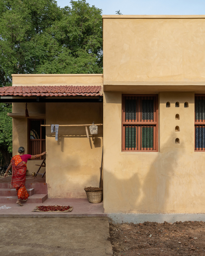 thousands of reclaimed bricks shape rural residence amid agricultural fields in india
