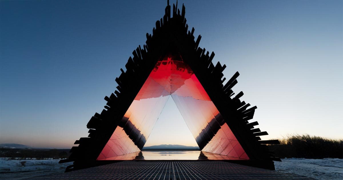 red chamber emerges from prism shelter’s charred wood shell