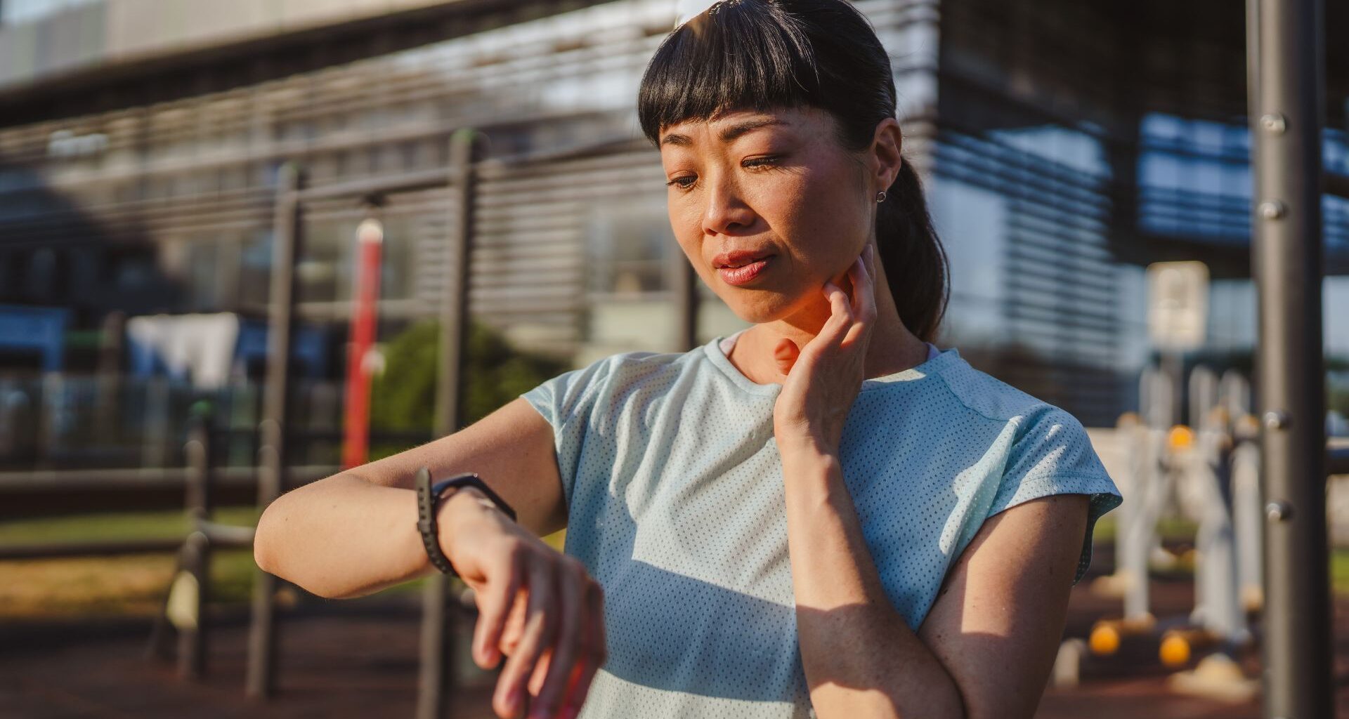 Woman using fitness tracker on wrist, looking at screen after workout