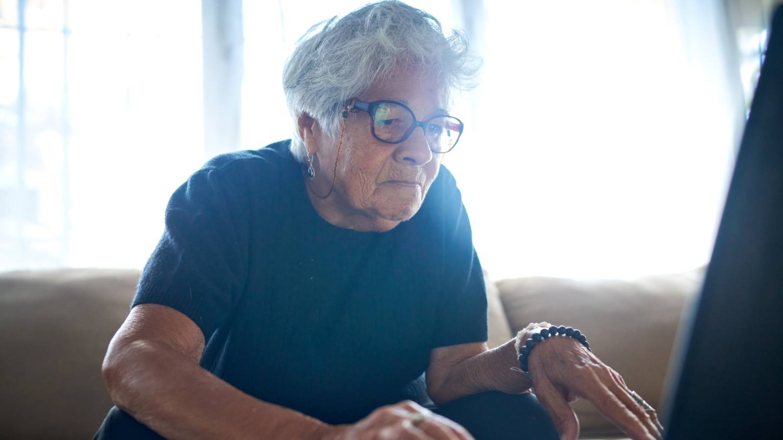 an older woman using a computer at home