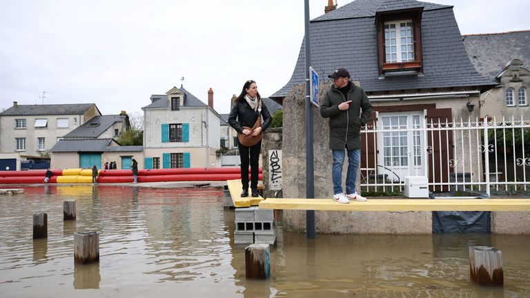 Residents on a makeshift walkway alongside homes in a flooded area near Angers, western France. Pic: Reuters