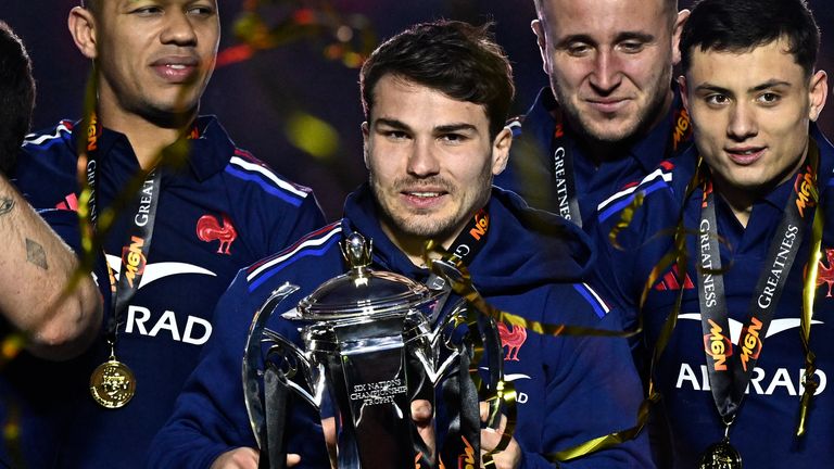 France's scrum-half Antoine Dupont (C) holds the trophy while celebrating winning the Six Nations international rugby union tournament at the end of France's match against Scotland, at Stade de France in Saint-Denis, Paris' suburb, on March 15, 2025. (Photo by JULIEN DE ROSA / AFP)