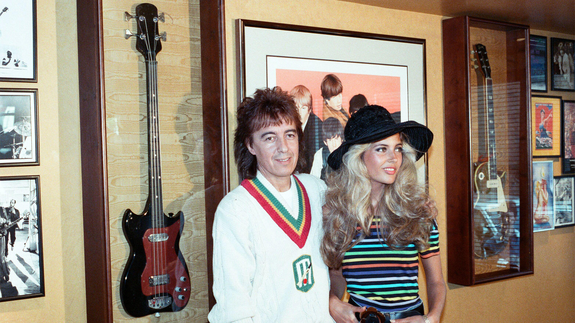 Bill Wyman and his former wife Mandy Smith at the opening of his Sticky Fingers restaurant in Kensington. 9th May 1989. The modified Dallas Tuxedo bass he played in the Rolling Stones is in the glass case behind him.