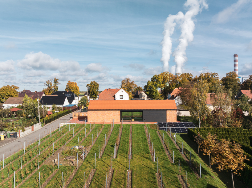 barrel-vaulted concrete cellar organizes vineyard building in poland