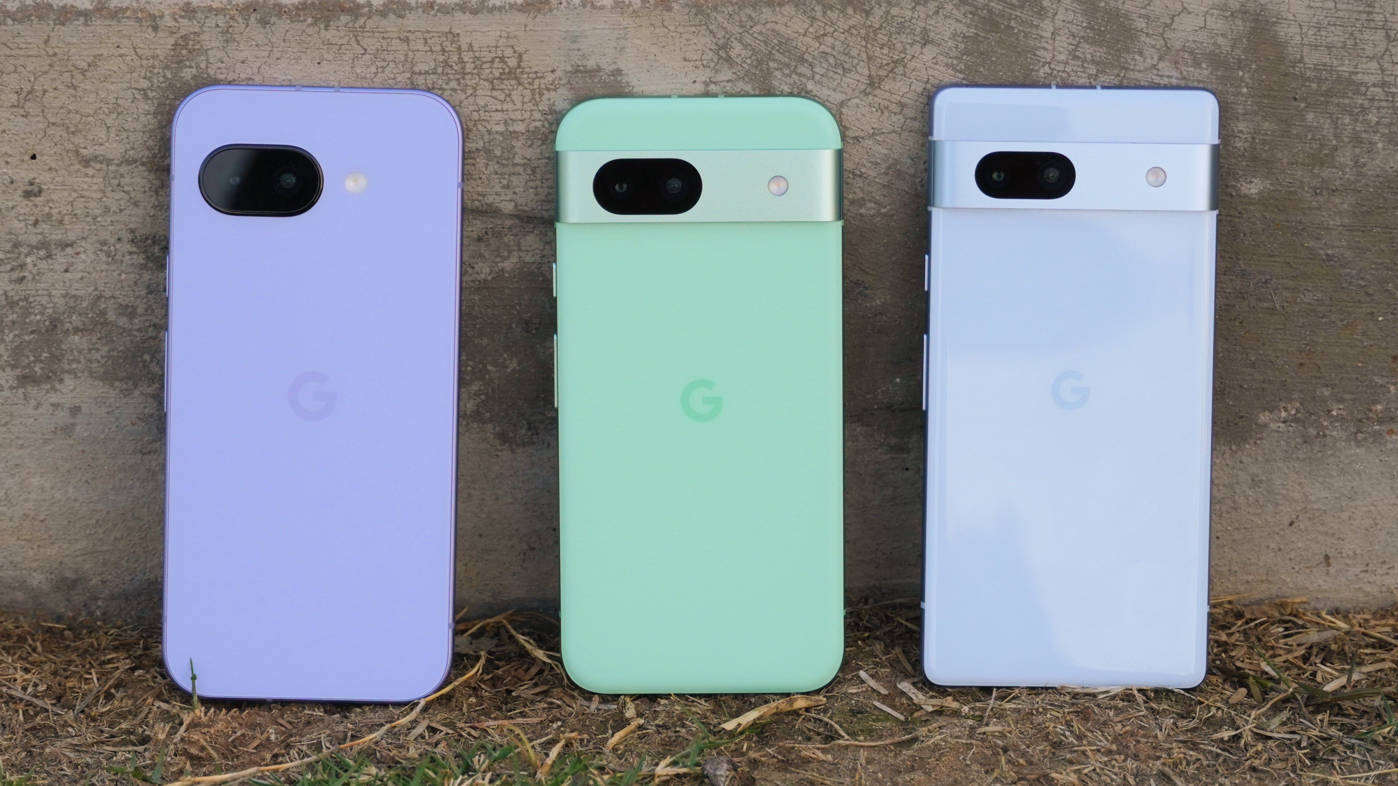 The Pixel 9a in Iris beside the Pixel 8a in Aloe and Pixel 7a in Bay.