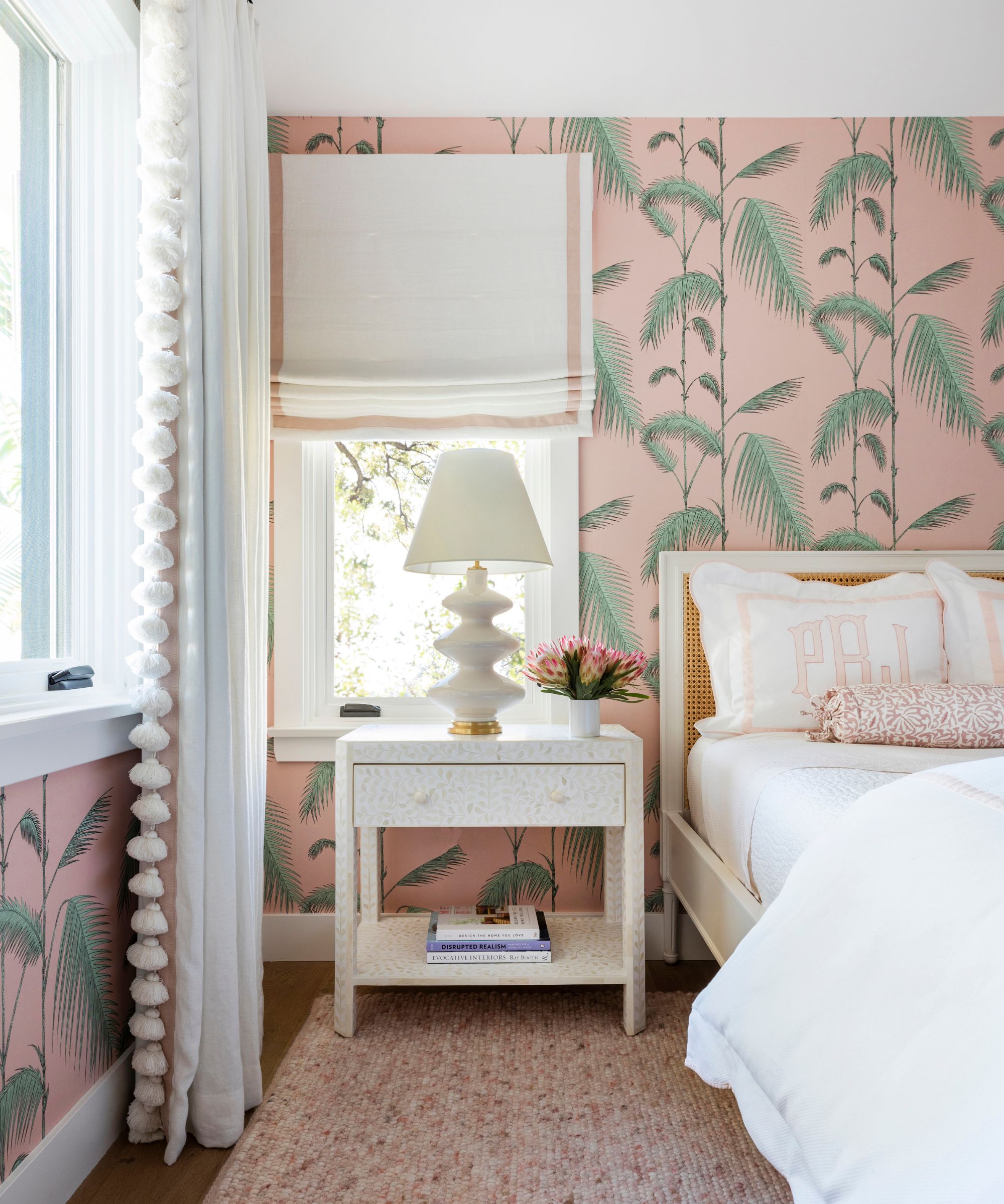 Bedroom with a soft pink palm print wallpaper paired with white curtains and blinds