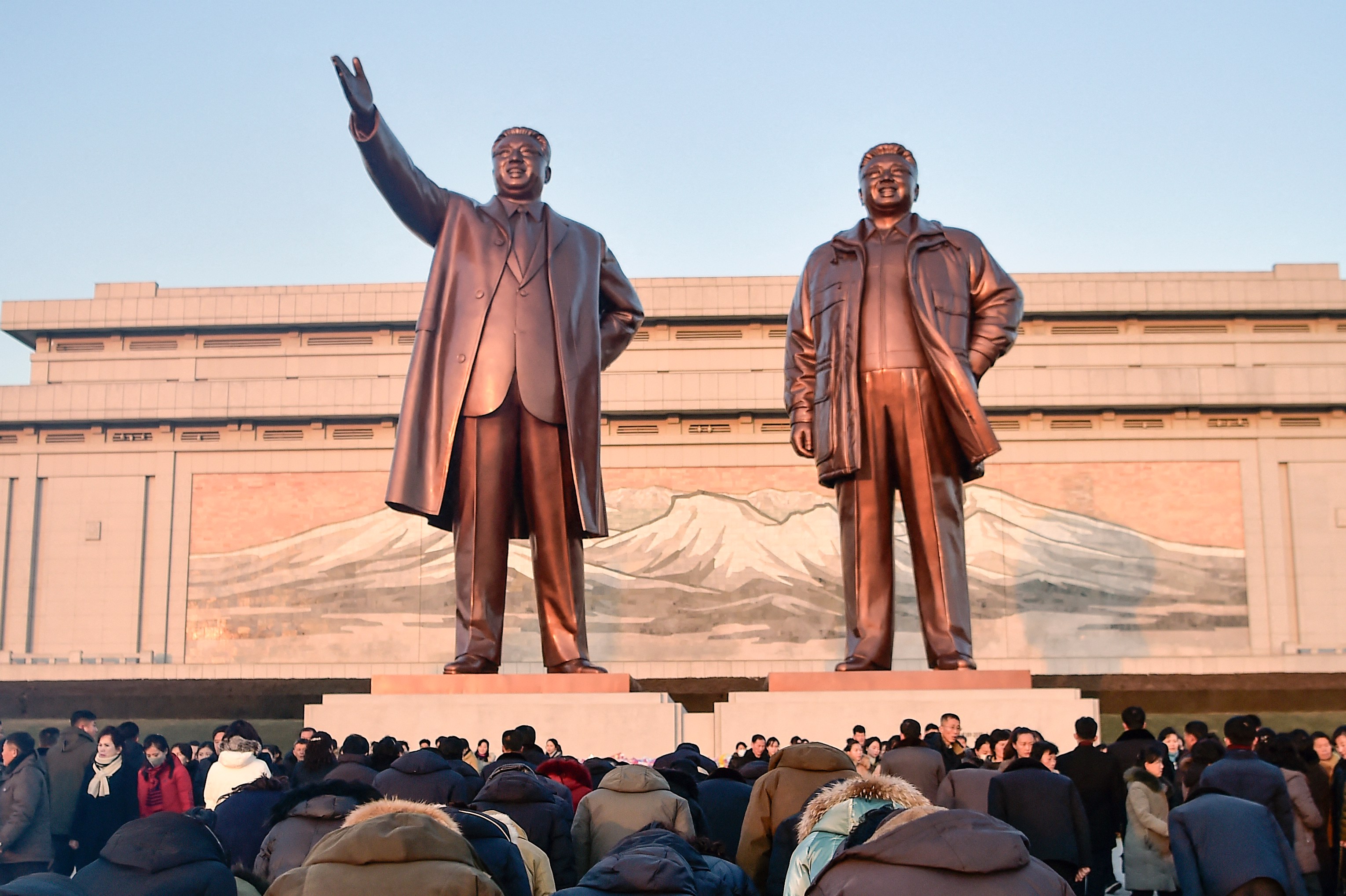People bowing before statues of Kim Il Sung and Kim Jong Il at Mansu Hill.