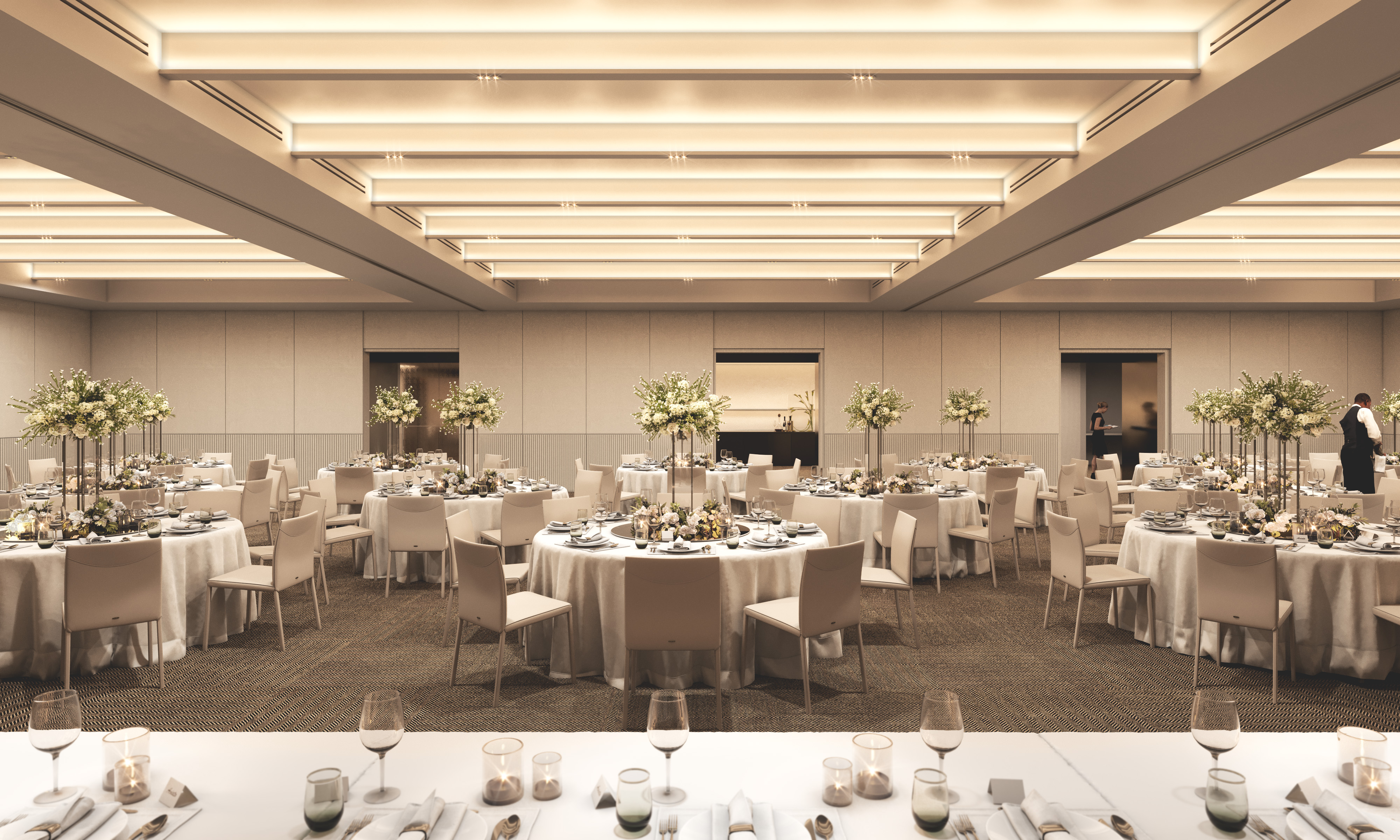 Illustration of a ballroom set up with numerous round tables for an event, each adorned with floral centerpieces and formal place settings, with a long rectangular table in the foreground also set for dining.