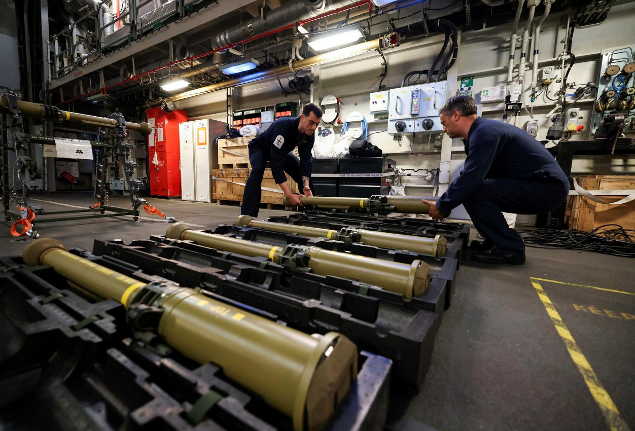 Aircraft engineers loading martlet missiles in a hanger.