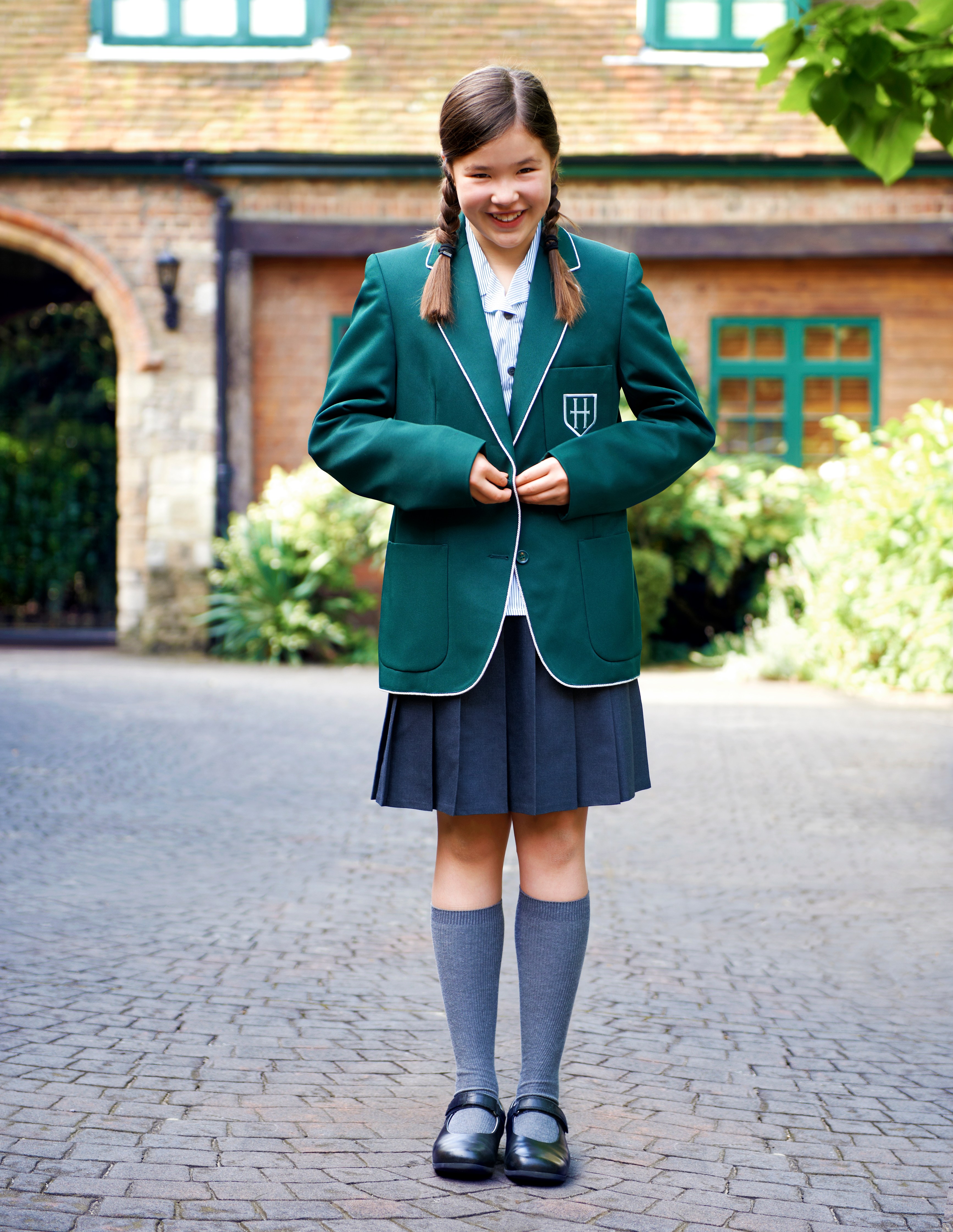 A smiling schoolgirl in uniform on her first day of senior school.