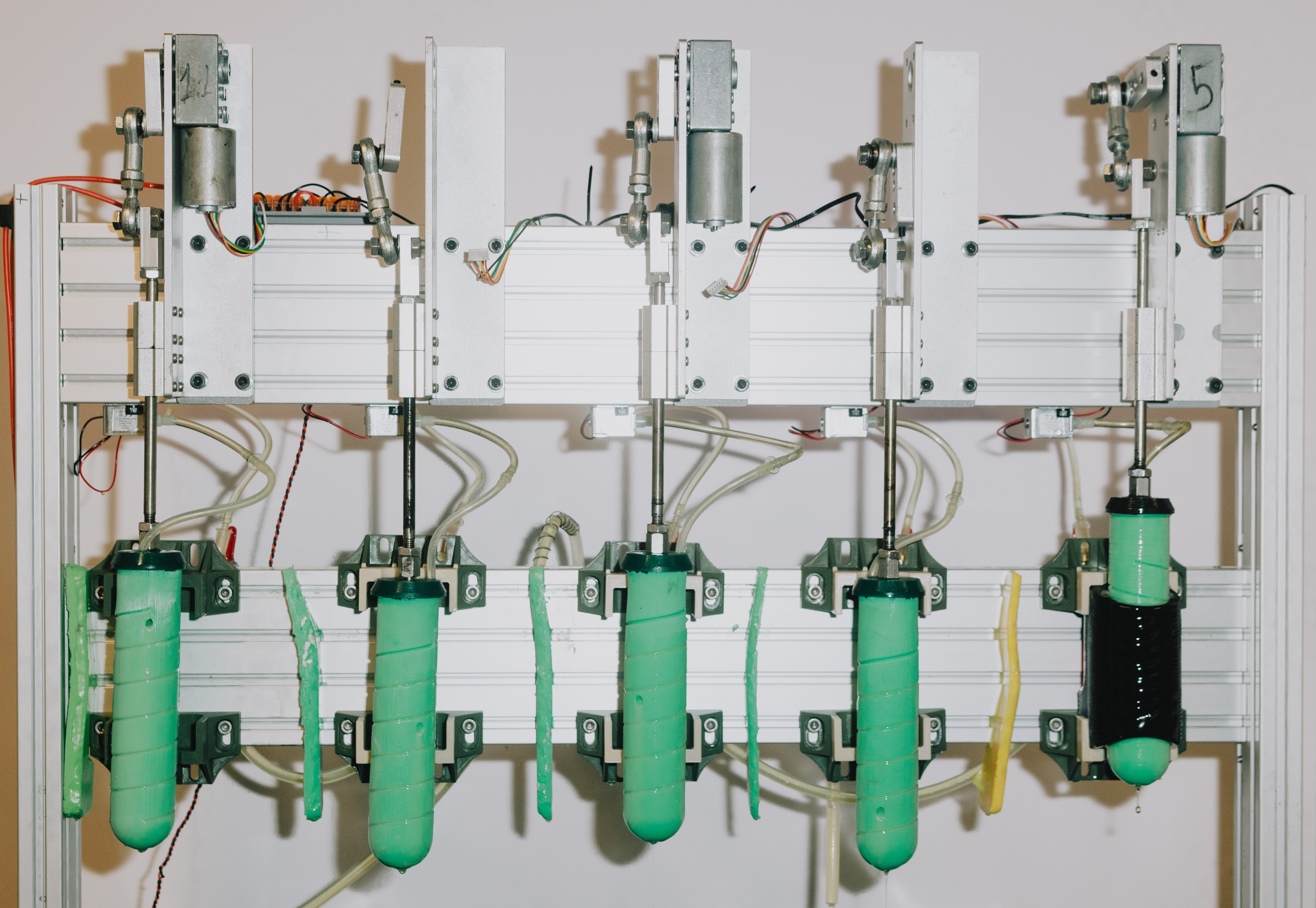 A machine with five green cylinders creating sex toys.