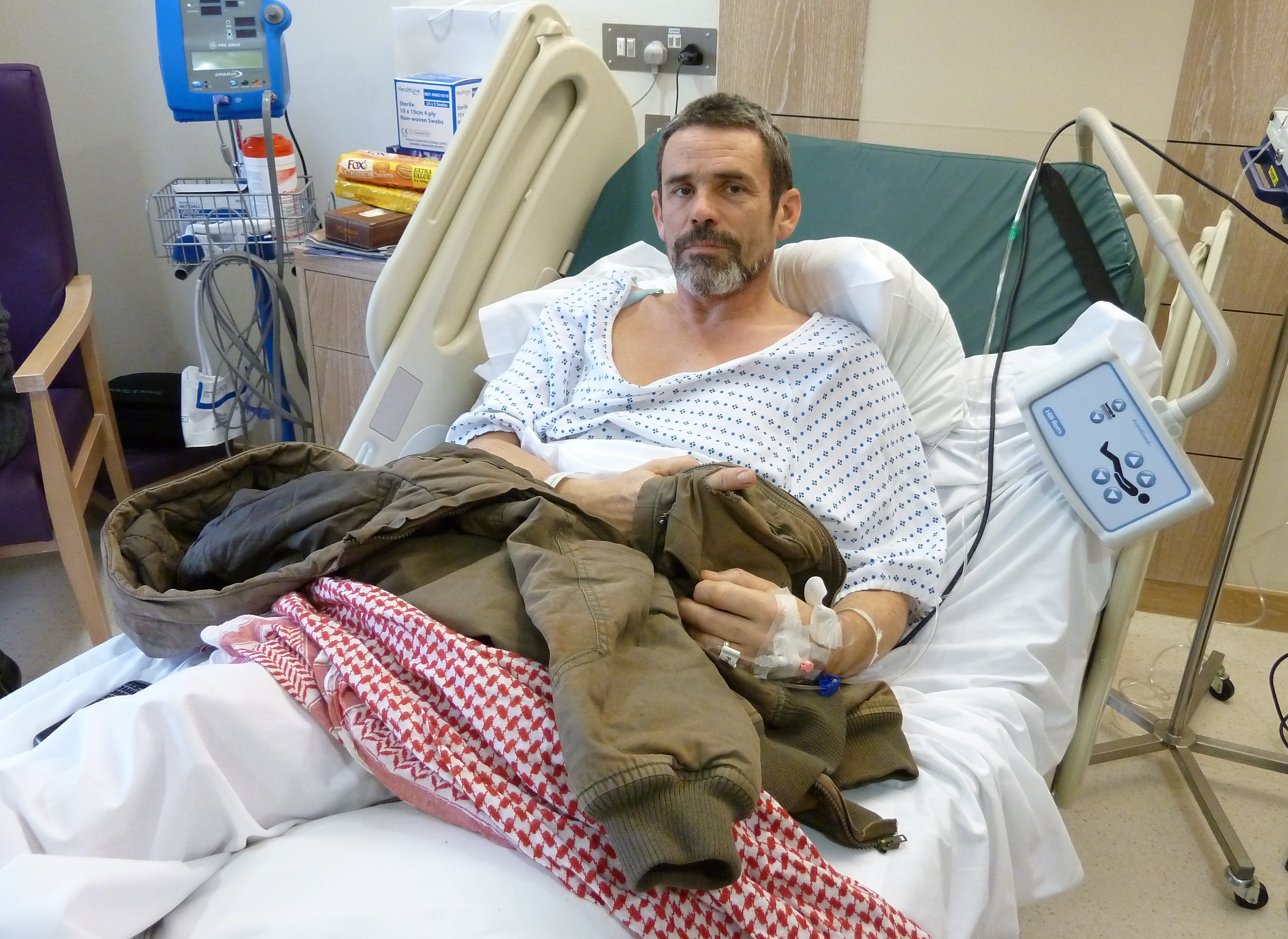 Photographer Paul Conroy in a hospital bed after a missile strike in Syria.