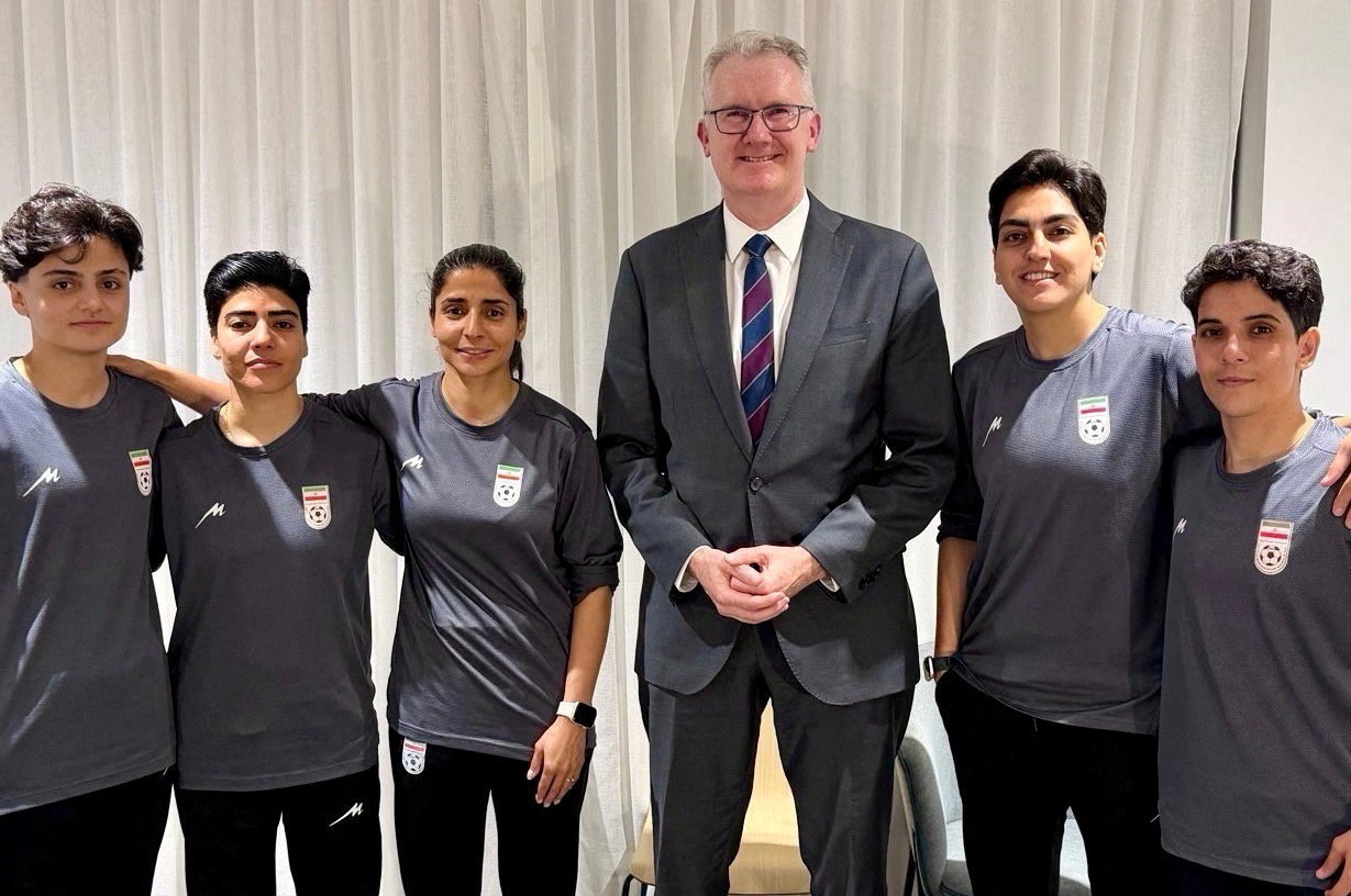 The Australian home affairs minister, Tony Burke, poses with five Iranian footballers who have sought protection in Australia
