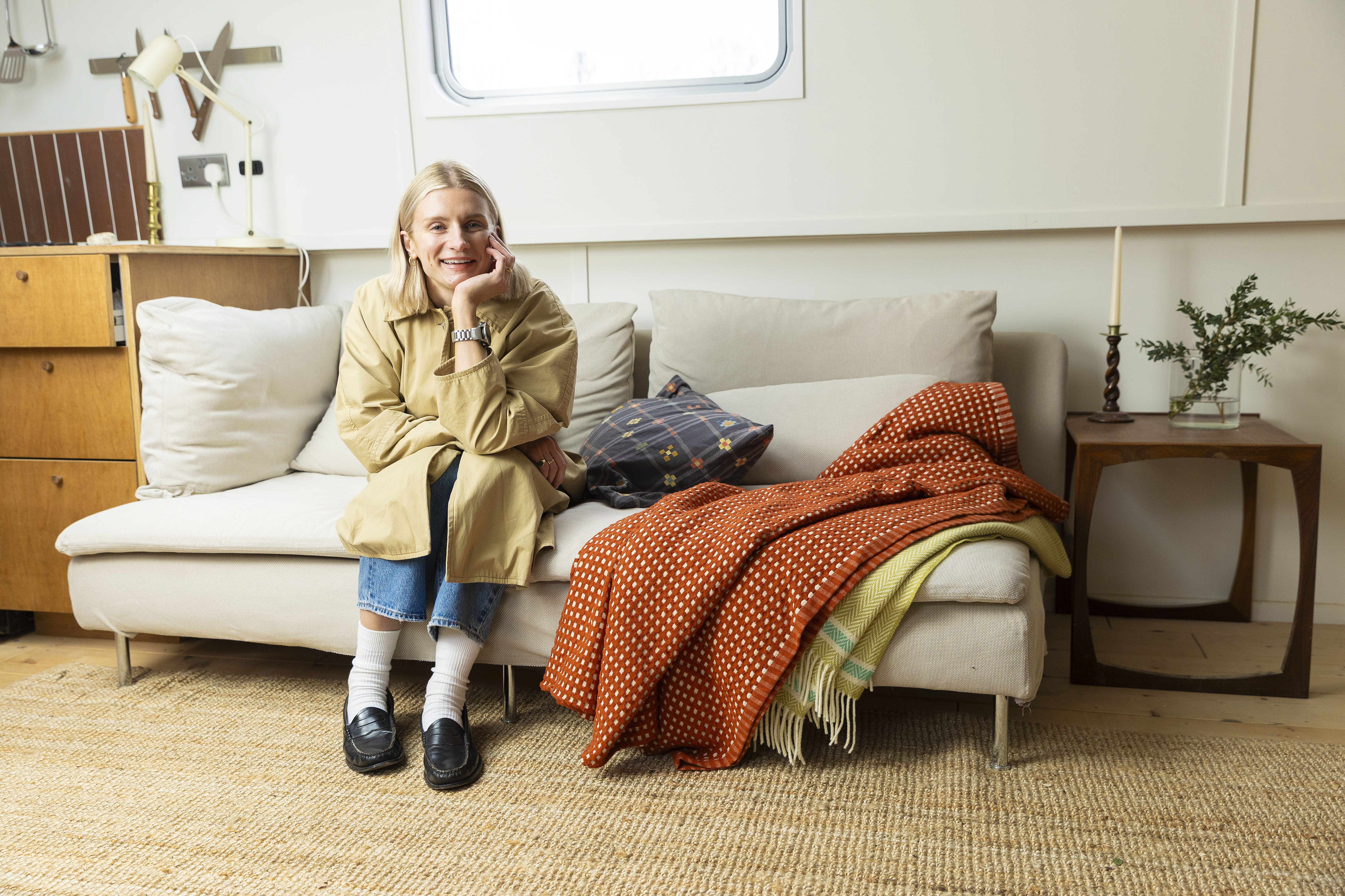Rosanna Irwin sits on a couch inside her houseboat.