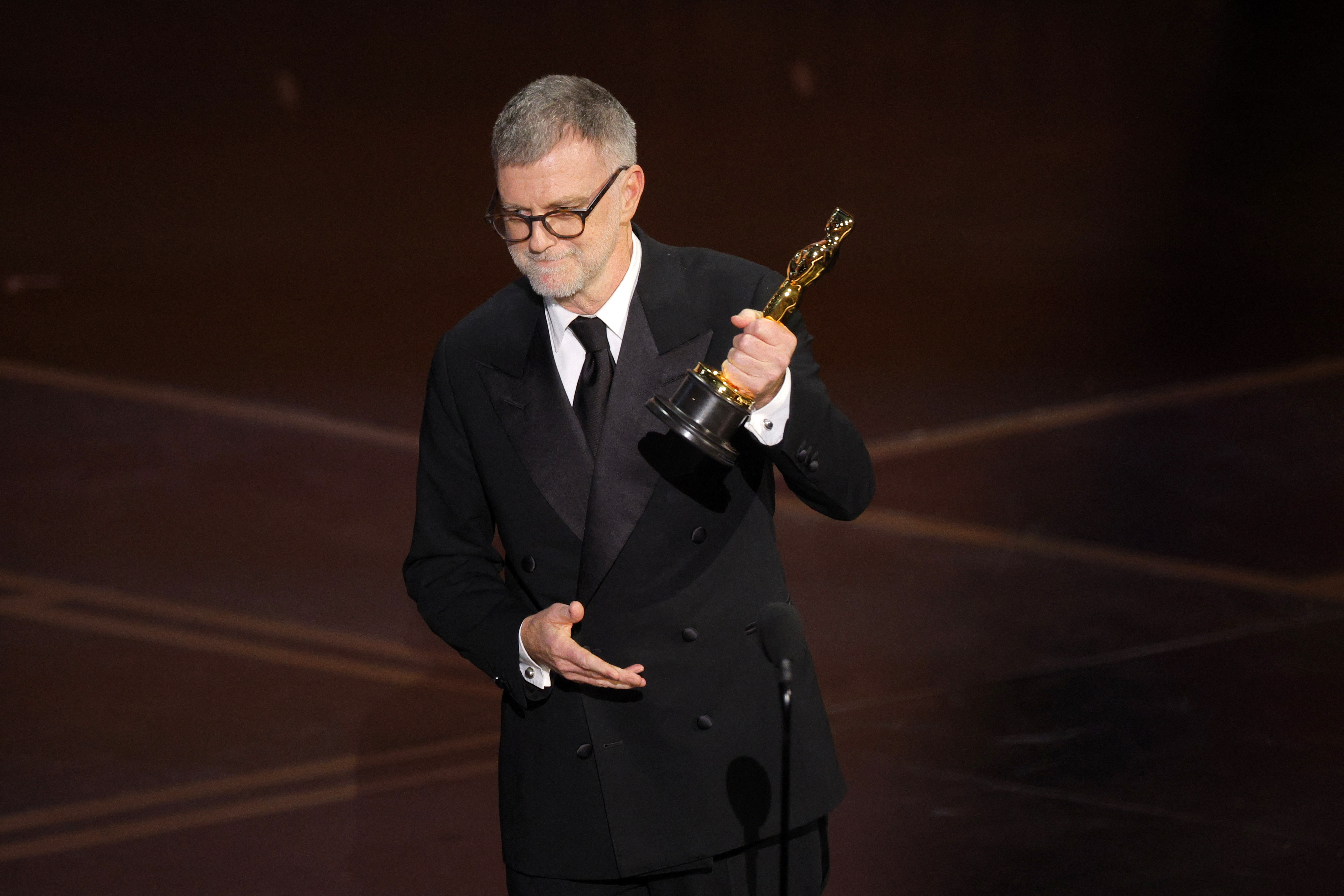 Paul Thomas Anderson holding an Oscar award.
