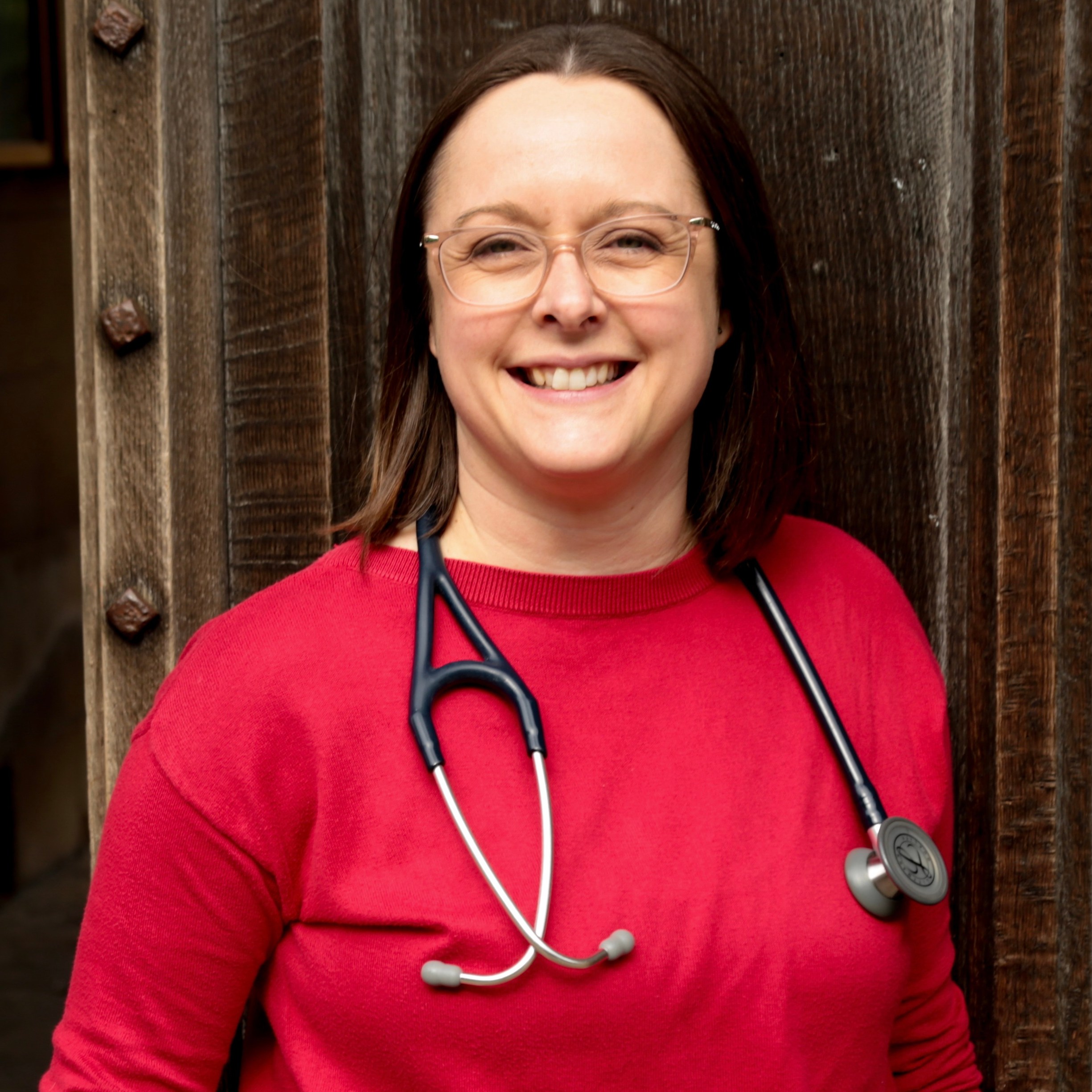 Dr. Susanna Unsworth smiling while wearing a red top and a stethoscope.