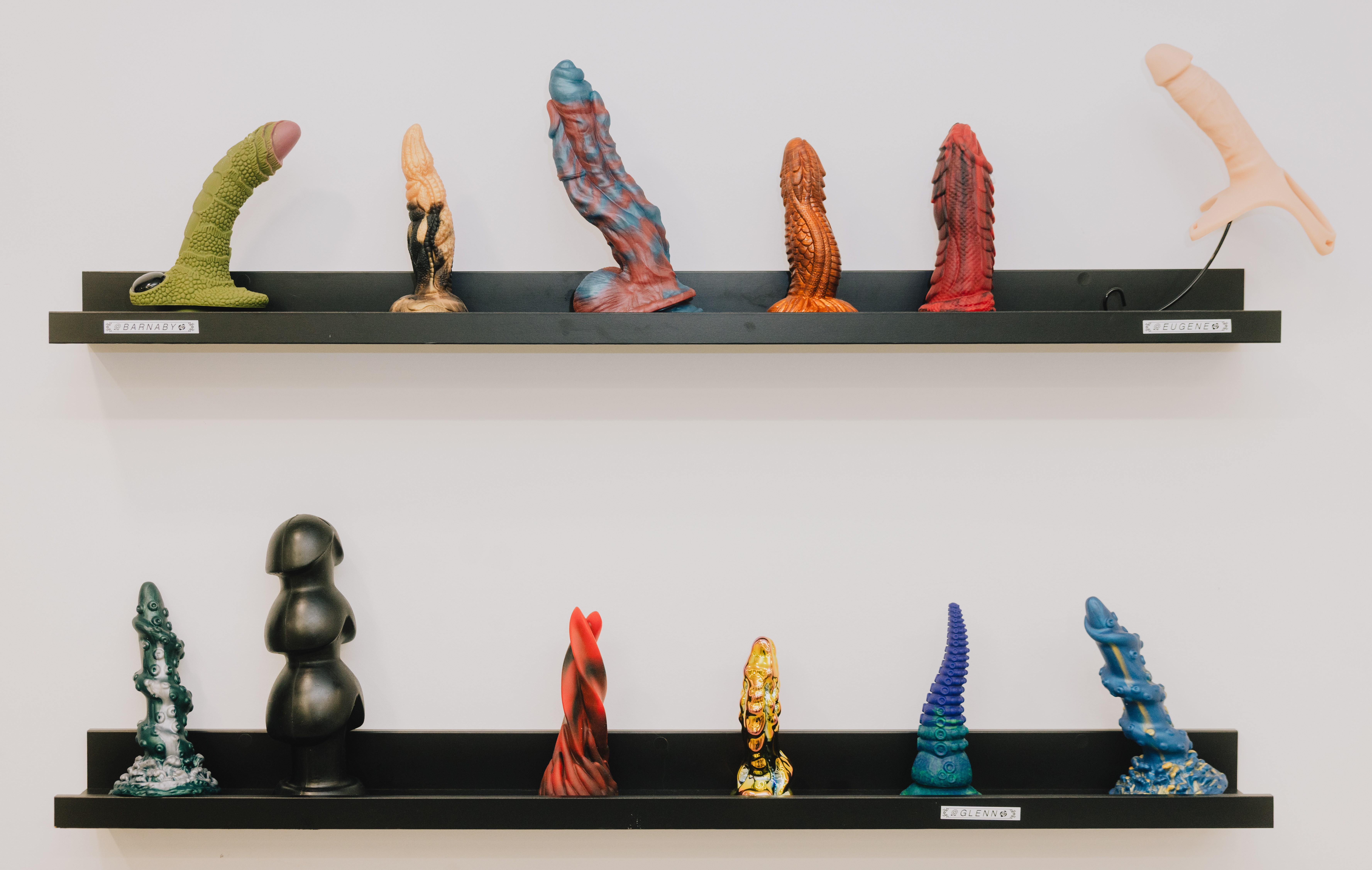 Two shelves displaying various colorful sex toys.