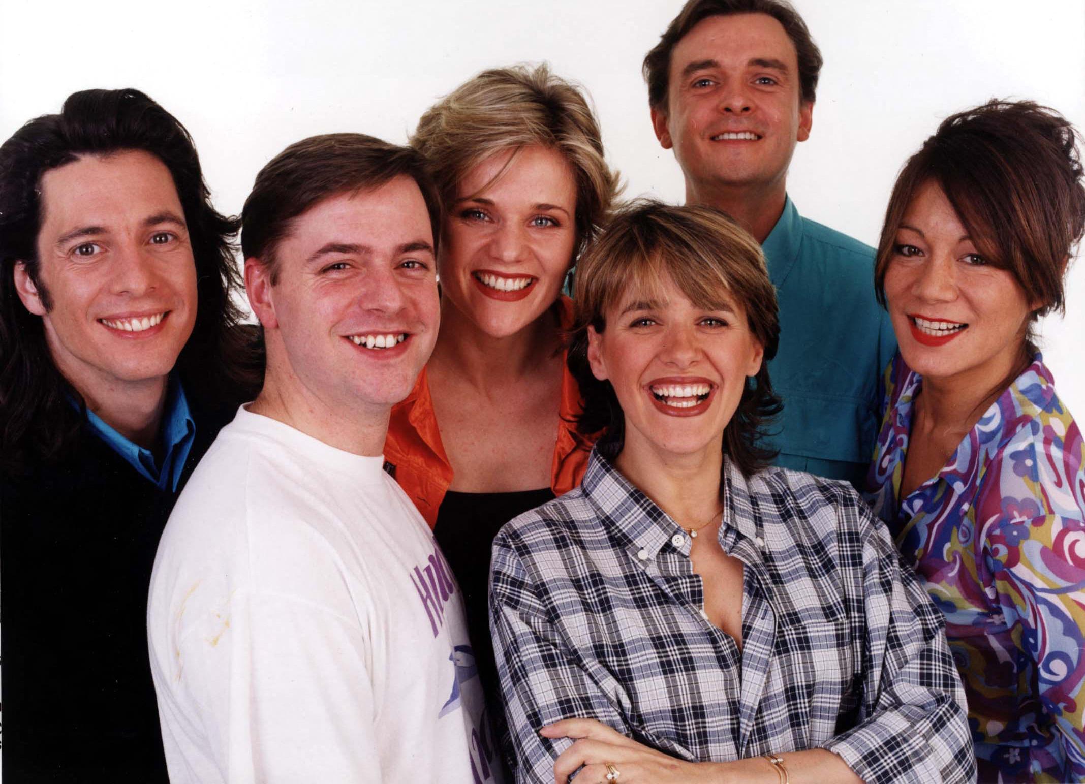 A group photo of the Changing Rooms cast including Laurence Llewelyn Bowen, Andy Kane, Linda Barker, Carol Smillie, Graham Wynne, and Anna Ryder Richardson.