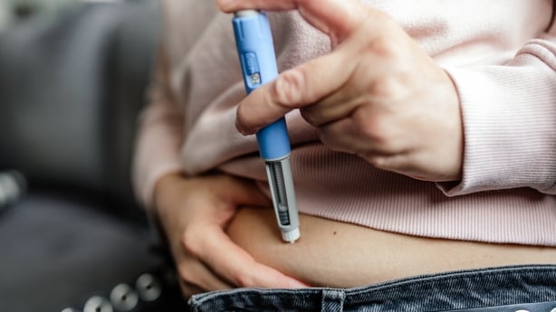 A woman performs a subcutaneous self-injection with a semaglutide pen into her abdomen