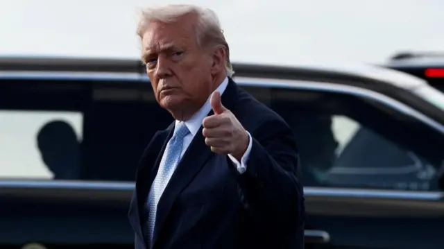 President Donald Trump holds a thumb up to the cameras as he arrives in West Palm Beach, Florida, on Friday